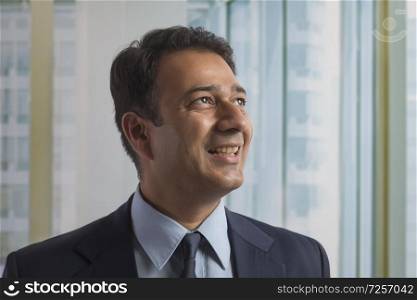 Close up of a smiling businessman in office looking away