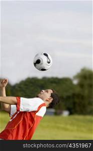 Close-up of a soccer player heading a soccer ball