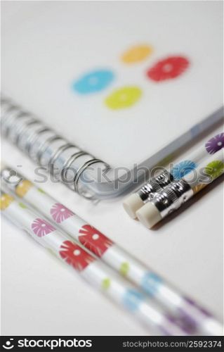 Close-up of a spiral notebook with pencils