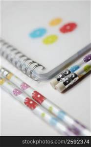 Close-up of a spiral notebook with pencils