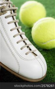 Close-up of a sports shoe and two tennis balls