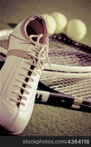 Close-up of a sports shoe with tennis rackets and tennis balls