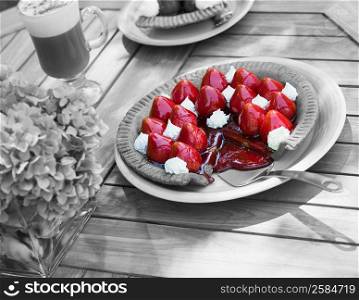 Close-up of a strawberry tart and a glass of chocolate milkshake on a table
