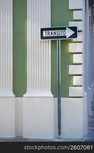 Close-up of a street name sign in front of a building
