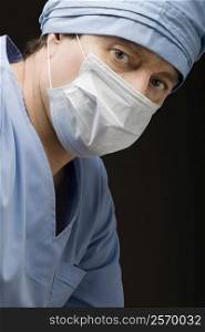 Close-up of a surgeon wearing scrubs and a surgical mask