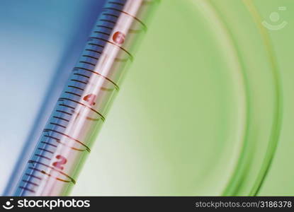 Close-up of a syringe with a petri dish