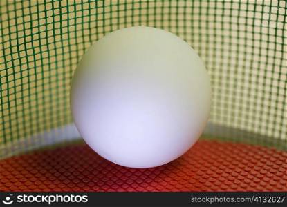 Close-up of a table tennis ball on a red table tennis racket
