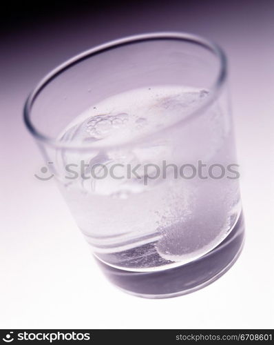 Close-up of a tablet dissolving a glass of water