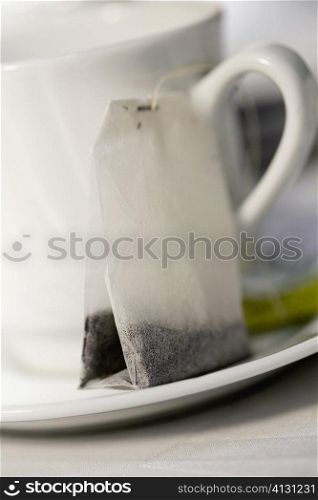 Close-up of a tea cup and a teabag in a saucer