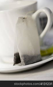 Close-up of a tea cup and a teabag in a saucer