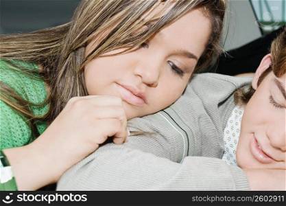Close-up of a teenage boy and a young woman resting together