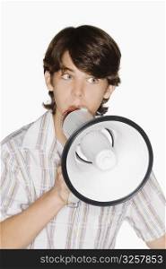 Close-up of a teenage boy blowing a bullhorn