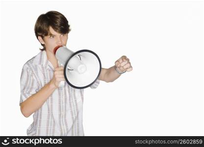 Close-up of a teenage boy blowing a bullhorn and pointing forward
