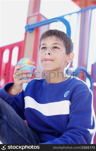 Close-up of a teenage boy holding an ice-cream cone