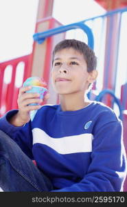 Close-up of a teenage boy holding an ice-cream cone