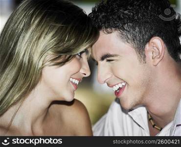 Close-up of a teenage boy looking at a young woman and smiling