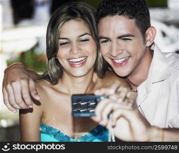 Close-up of a teenage boy taking a picture of himself with a young woman