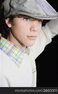 Close-up of a teenage boy wearing a flat cap