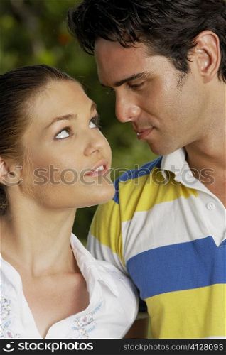 Close-up of a teenage girl and a young man looking at each other