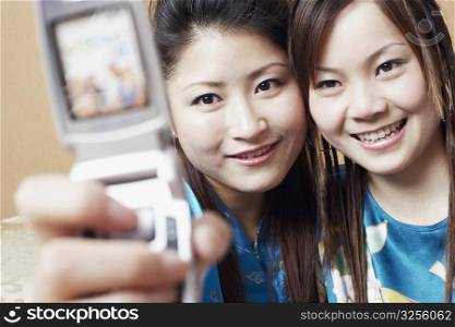 Close-up of a teenage girl and a young woman taking a photograph of themselves