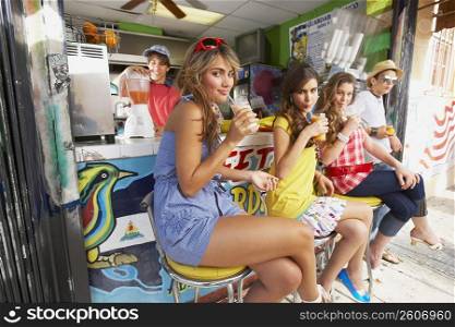 Close-up of a teenage girl drinking juice with her friends