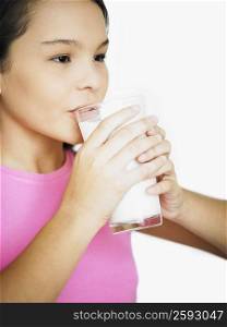 Close-up of a teenage girl drinking milk from a glass