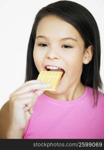 Close-up of a teenage girl eating a biscuit