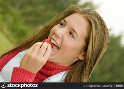 Close-up of a teenage girl eating a strawberry