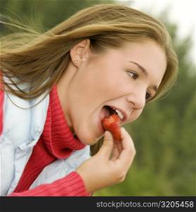 Close-up of a teenage girl eating a strawberry