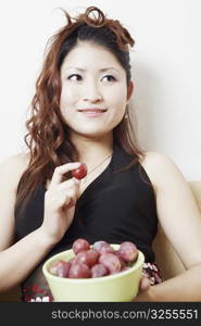 Close-up of a teenage girl holding a bowl of plums