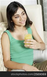 Close-up of a teenage girl holding a glass of orange juice