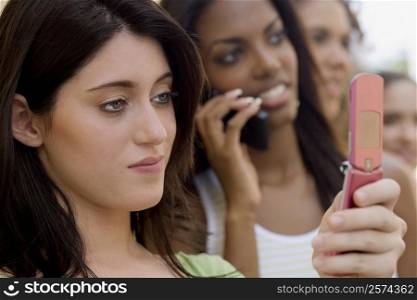Close-up of a teenage girl holding a mobile phone and thinking