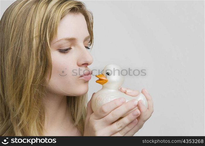 Close-up of a teenage girl kissing a rubber duck