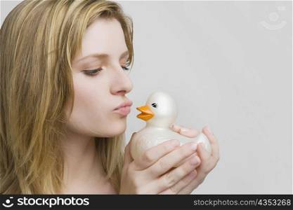 Close-up of a teenage girl kissing a rubber duck