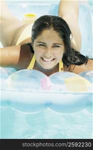 Close-up of a teenage girl lying on a pool raft