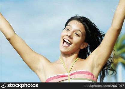Close-up of a teenage girl shouting with her arms raised