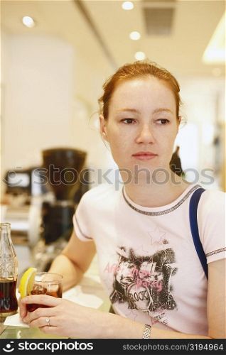 Close-up of a teenage girl sitting at a bar counter