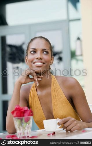 Close-up of a teenage girl sitting in a restaurant with a cup of coffee