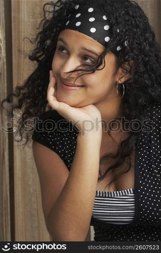 Close-up of a teenage girl smiling with her hand on her chin