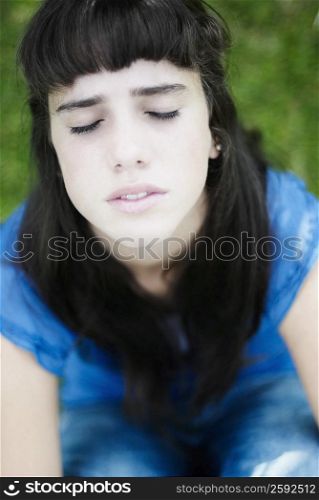 Close-up of a teenage girl thinking with her eyes closed