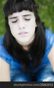 Close-up of a teenage girl thinking with her eyes closed