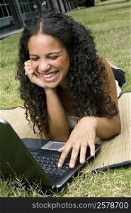 Close-up of a teenage girl using a laptop and smiling