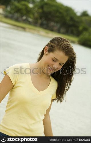 Close-up of a teenage girl walking on the beach smiling