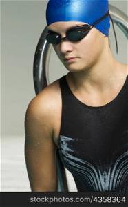 Close-up of a teenage girl wearing a swimming cap and swimming goggles