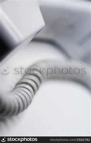 Close-up of a telephone receiver with a phone cord