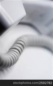 Close-up of a telephone receiver with a phone cord