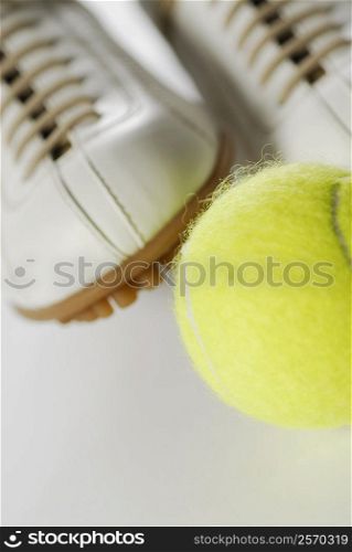 Close-up of a tennis ball and a pair of sports shoes