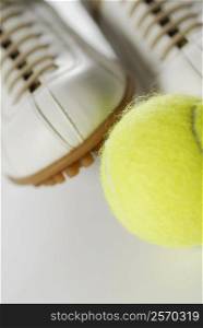 Close-up of a tennis ball and a pair of sports shoes