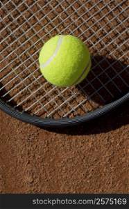 Close-up of a tennis ball on a racket in a court