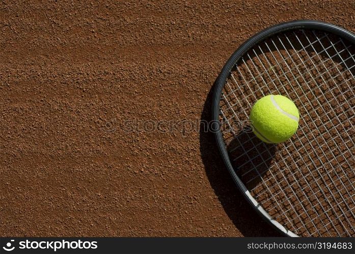 Close-up of a tennis ball on a racket in a court